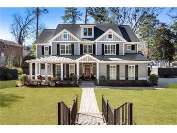 Charming two-story home with gray siding, black shutters, inviting front porch, and lush green lawn at 2190 Rugby Ave, Atlanta, GA 30337