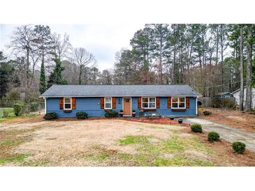 Charming single-story home with a blue exterior, wooden shutters, and a well-maintained front yard at 3653 Memorial Nw Pkwy, Kennesaw, GA 30152