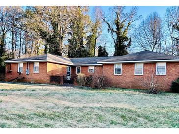 Charming single-story brick home with a well-maintained lawn and mature trees at 3112 Laura Ln, Lithia Springs, GA 30122