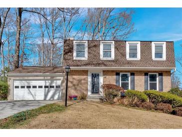 Charming brick home featuring a manicured lawn, attached garage and classic architectural details at 3461 Valley View Dr, Marietta, GA 30068