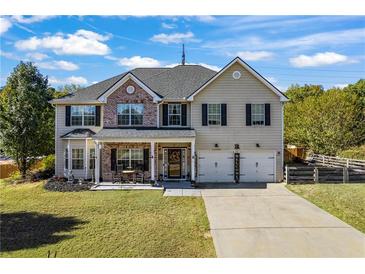 Charming two-story home with brick accents, landscaped yard, and welcoming front porch at 2316 Watson Fain Trl, Loganville, GA 30052