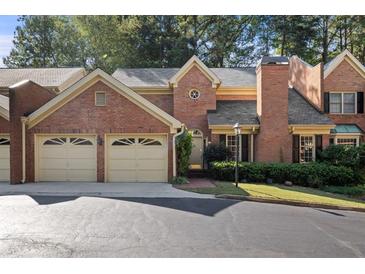 Charming brick townhome with a two-car garage and manicured landscaping at 52 Ivy Chase Ne, Atlanta, GA 30342