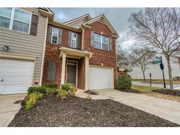 Charming brick townhome featuring a one car garage, inviting curb appeal, and manicured landscaping at 3374 Thornbridge Dr, Powder Springs, GA 30127