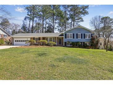 Charming blue two-story home with lush green lawn, mature trees, and attached two-car garage at 860 Valleymeade Se Dr, Marietta, GA 30067