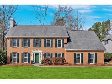 Charming brick home featuring dark shutters, a manicured lawn, and a classic architectural style at 1293 Wynford Colony Sw, Marietta, GA 30064