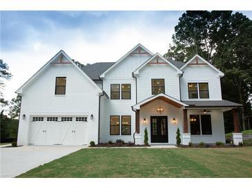 Beautiful two-story home featuring a white brick and siding exterior with a two-car garage and a covered front porch at 1533 Grayson Pkwy, Grayson, GA 30017