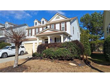 Charming two-story home featuring a well-manicured front yard and a two-car garage at 4402 Alysheba Dr, Fairburn, GA 30213