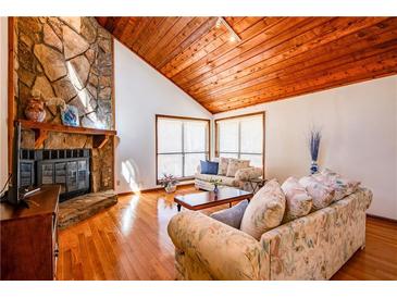 Cozy living room features a stone fireplace, wood ceilings, and large windows at 2191 Spear Point Dr, Marietta, GA 30062