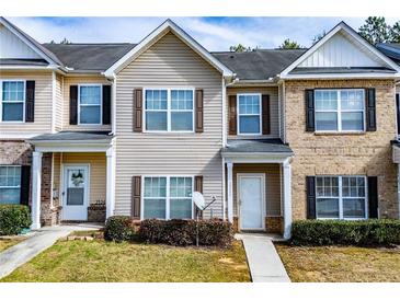 Inviting townhouse exterior with neutral siding, shutters, and well-maintained landscaping at 2326 Bigwood Trl, Atlanta, GA 30349