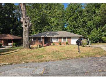 Cozy brick home featuring an attached garage and a well-maintained front yard with mature trees at 2723 Altaview Se Dr, Atlanta, GA 30354