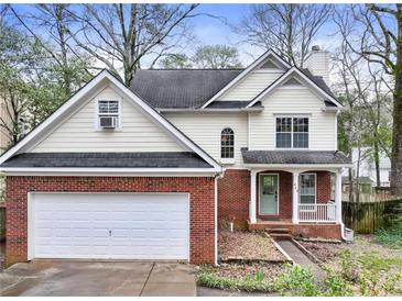 Charming two-story home with a brick facade, attached garage, front porch, and a well-maintained yard at 447 Hemlock Dr, Pine Lake, GA 30083