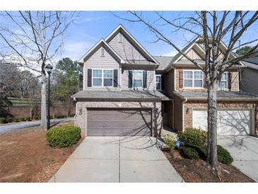 Charming townhome featuring a brick and siding exterior with an attached two-car garage at 1945 Bay Beauty Ln # 10, Austell, GA 30106