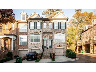 Charming brick townhouse with two-car garage, well-maintained landscaping, and inviting front entrance with a stone stairway at 2661 Rivers Edge Ne Dr, Atlanta, GA 30324