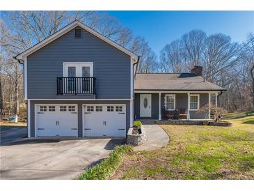 Charming exterior featuring a two-car garage, balcony, and well-maintained lawn at 2421 Pittman Cir, Cumming, GA 30040