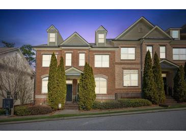 Charming brick townhome featuring manicured landscaping and classic architectural details at 7420 Glisten Ave, Sandy Springs, GA 30328