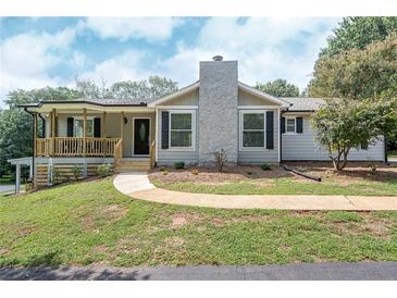 Charming single-story home with a stone chimney and welcoming front porch at 8321 Banks Mill Rd, Douglasville, GA 30135