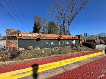 Landscaped community entrance featuring a brick sign with black background at 6026 Southland Dr, Stone Mountain, GA 30087