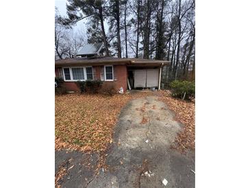 Charming brick home exterior with covered parking, solar panels, and mature trees at 3518 Hamlin Cir, Atlanta, GA 30341