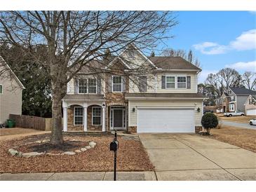 Charming two-story home featuring stone accents, neutral siding, a two-car garage, and a well-maintained front yard at 939 Mill Creek Ave, Canton, GA 30115