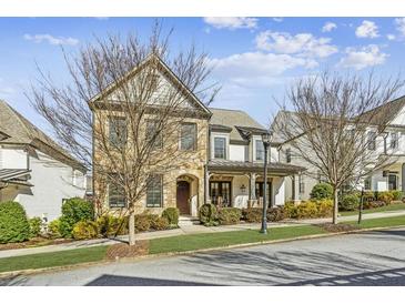 Charming two-story home with stone and painted brick exterior, complemented by mature landscaping at 231 Chastain Park Dr, Atlanta, GA 30342