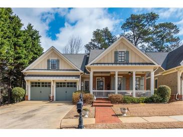 Charming home with a welcoming front porch, well-manicured lawn, and an attached two-car garage at 730 Jackson Miller Cir, Powder Springs, GA 30127