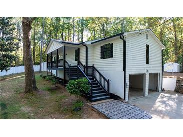 Charming home with a black and white exterior, landscaped yard and convenient two-car garage at 2450 Spring Mill Cv, Duluth, GA 30097