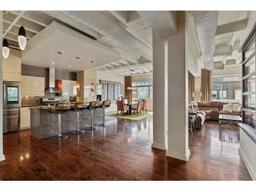 Bright open-concept living space with modern kitchen, dining area, and inviting living room with exposed duct work at 805 Peachtree Ne St # 614, Atlanta, GA 30308