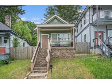 Charming home with a stone foundation and a covered front porch, enhanced by a well-maintained lawn at 490 Rockwell Sw St, Atlanta, GA 30310