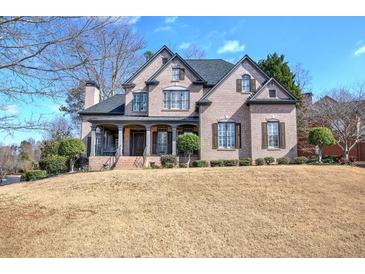 Elegant two-story brick home featuring a covered front porch and well-manicured landscaping, offering classic curb appeal at 3759 Maryhill Nw Ln, Kennesaw, GA 30152