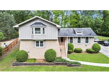 Charming home featuring a brick facade, complemented by lush landscaping and mature trees at 2657 Langland Ne Ct, Atlanta, GA 30345