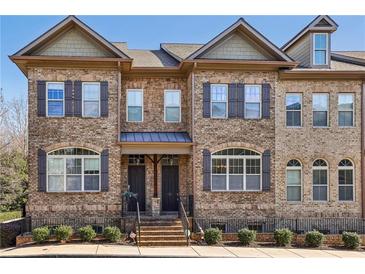 Charming brick townhome featuring beautiful architectural details and meticulously maintained landscaping at 911 Telfair Close, Sandy Springs, GA 30350