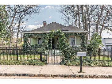 Charming home with beautiful foliage, well-maintained lawn and black fence at 3670 Union Ave, Atlanta, GA 30354