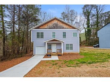 Charming two-story home with a garage and a well-maintained front yard at 6945 Merrywood Dr, Fairburn, GA 30213