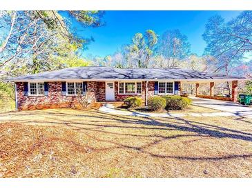 Charming brick home with a welcoming front yard and covered carport, perfect for outdoor living at 1650 Seayes Sw Rd, Mableton, GA 30126