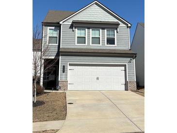 Charming two-story home featuring a gray siding, a two-car garage, and a well-maintained front lawn at 156 Auburn Crossing Dr, Auburn, GA 30011