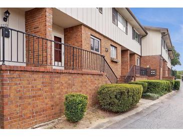 A brick townhouse exterior with green bushes and a black railing along the sidewalk at 2551 Bradford Ne Sq, Atlanta, GA 30345