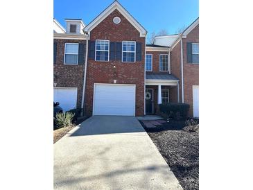 Charming brick townhome featuring a one car garage and driveway at 3148 Glenloch Pl, Lawrenceville, GA 30044