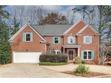 Charming brick home featuring a well-manicured front yard and two-car garage at 775 Hales Trace Sw Way, Lilburn, GA 30047