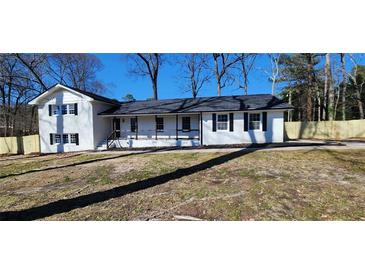 Charming white brick home with a welcoming front porch and freshly landscaped yard at 1390 White Oak St Se, Conyers, GA 30013