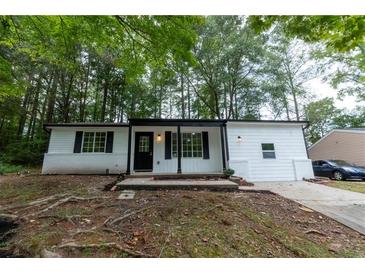 Charming single-story home featuring a welcoming front porch, freshly painted white exterior, and well-maintained landscaping at 1995 Northerly Way, Stone Mountain, GA 30088