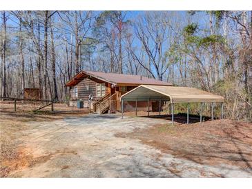 Charming cabin-style home with metal roof, wooden siding and a convenient carport at 2762 Zingara Ne Rd, Conyers, GA 30012