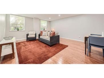 Bright living room featuring hardwood floors, windows, modern furniture and a vibrant rug at 2965 Pharr Court South Nw # 110, Atlanta, GA 30305