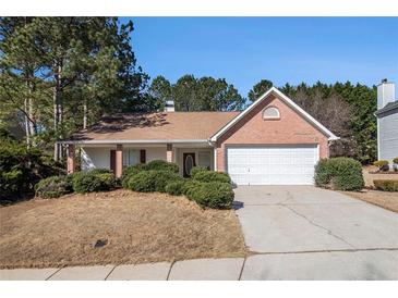 Charming one-story brick home featuring a two-car garage and mature landscaping at 11941 Fairway Overlook, Fayetteville, GA 30215