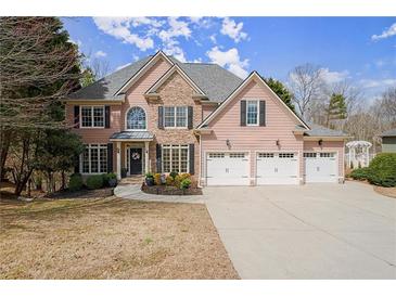 Charming two-story home featuring a stone accent, three-car garage, manicured lawn and inviting front entrance at 403 Mill Xing, Canton, GA 30114