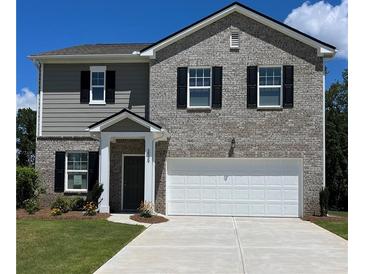 Charming two-story home features a mix of gray siding and brick, a two-car garage, and a well-maintained front yard at 167 Silverton Dr, Dacula, GA 30019