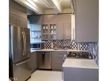 Modern kitchen features stainless steel appliances, grey cabinets, and a unique backsplash at 2479 Peachtree Ne Rd # 1115, Atlanta, GA 30305