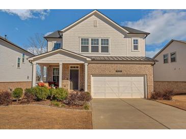 Charming two-story home featuring a brick and siding facade, covered porch, and attached two-car garage at 5345 Coltman Dr, Cumming, GA 30028