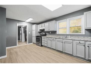 Updated kitchen featuring stainless steel appliances, light grey cabinets, and wood floors at 391 Mount Zion Sw Rd, Atlanta, GA 30354