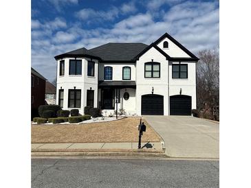 Charming two-story home showcases a white painted brick facade, contrasting black trim and a well-manicured front yard at 5004 Duxford Se Dr, Smyrna, GA 30082