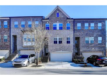 Charming brick townhomes feature attached garages and a traditional architectural style at 373 Via Secco Ln, Suwanee, GA 30024